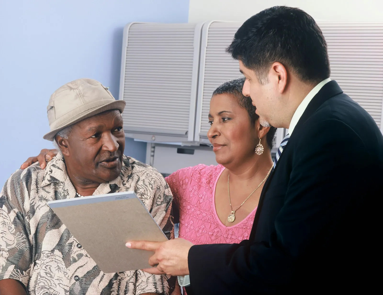 An older man and his daughter reviewing paperwork with an advisor